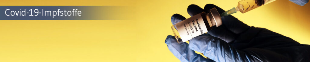 Hand mit blauen Handschuhen hält eine Spritze und eine Flasche mit Aufschrift 'Coronavirus Vaccine Covid-19'